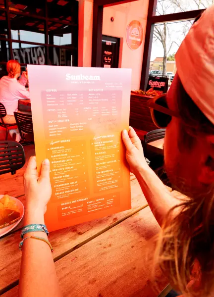 Person holding the fuoco menu while sitting on the patio